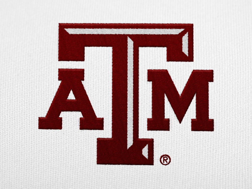 A maroon A&M logo embroidered on a white shirt